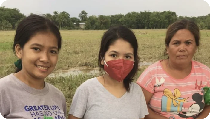 KBH Borydning uddeler velgørenhed på en mark til tre kvinder