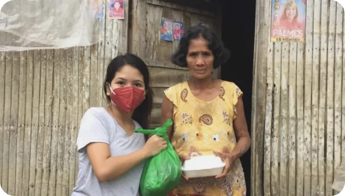 KBH Borydning leverer velgørenhedspakke til to kvinder foran et hus