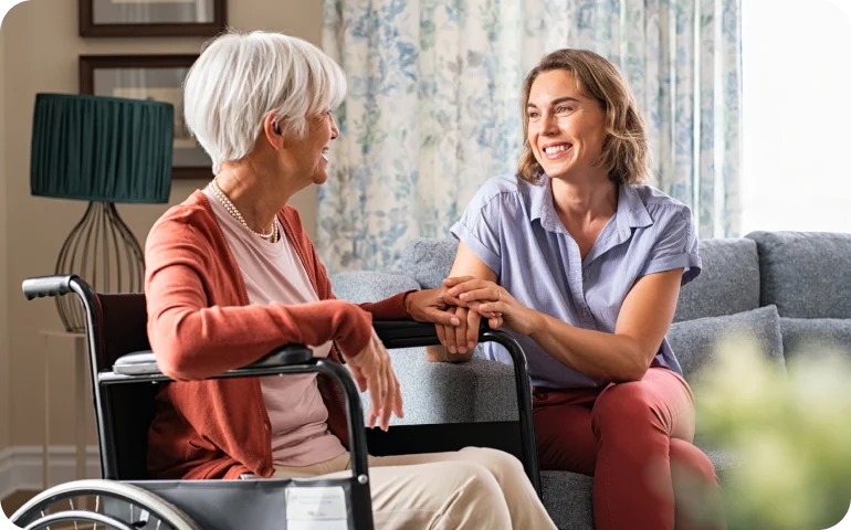 Medarbejder fra KBH Borydning taler med ældre kvinde i kørestol, viser omsorg ved borydning